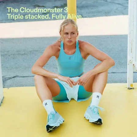 An On ad creative: a runner in a turquoise kit crouched on a yellow kerb in Cloudmonster 3 trainers
