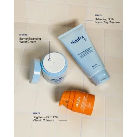 A Skinfix image ad: a cleanser, a vitamin C serum and a water cream on bathroom tile, each labelled step 01, 02 and 03