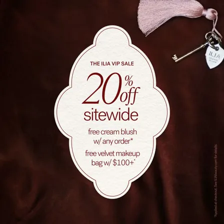 An ILIA ad creative: a cream label on dark velvet reading twenty percent off sitewide with free gifts, beside a tasselled key