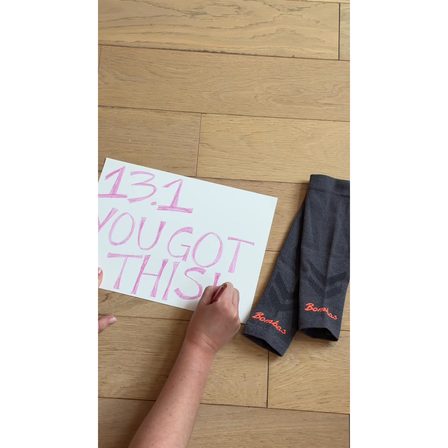 A UGC ad showing a handwritten half marathon sign beside a pair of socks