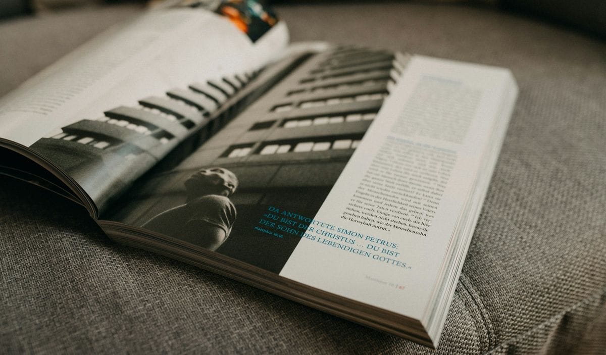 An open magazine with a full-page photo lies on a sofa: a brand magazine like The Furrow was read at home, page by page