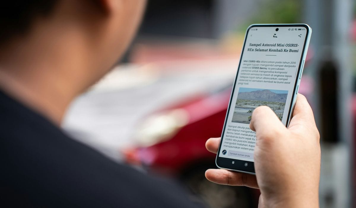 A person scrolls a long news article on a smartphone: most advertorial landing pages are read exactly like this, one thumb at a time
