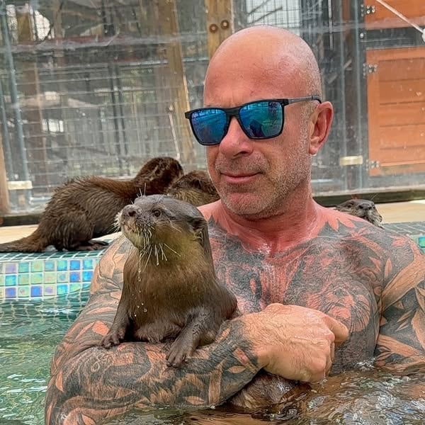 An ad by Animal EDventure Park & Safari in Meta's Ad Library: a tattooed man in a pool holds an otter, under the question Do you really want to play with our otters?