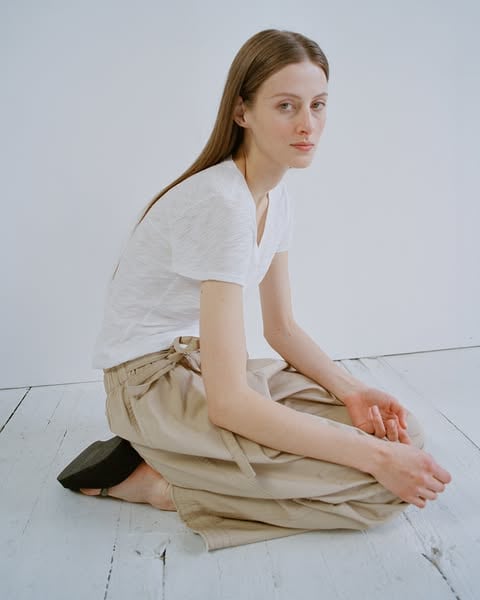 An ad by ATM Anthony Thomas Melillo in Meta's Ad Library: a model in a white t-shirt sits on a wooden floor in the beige Judo Pant
