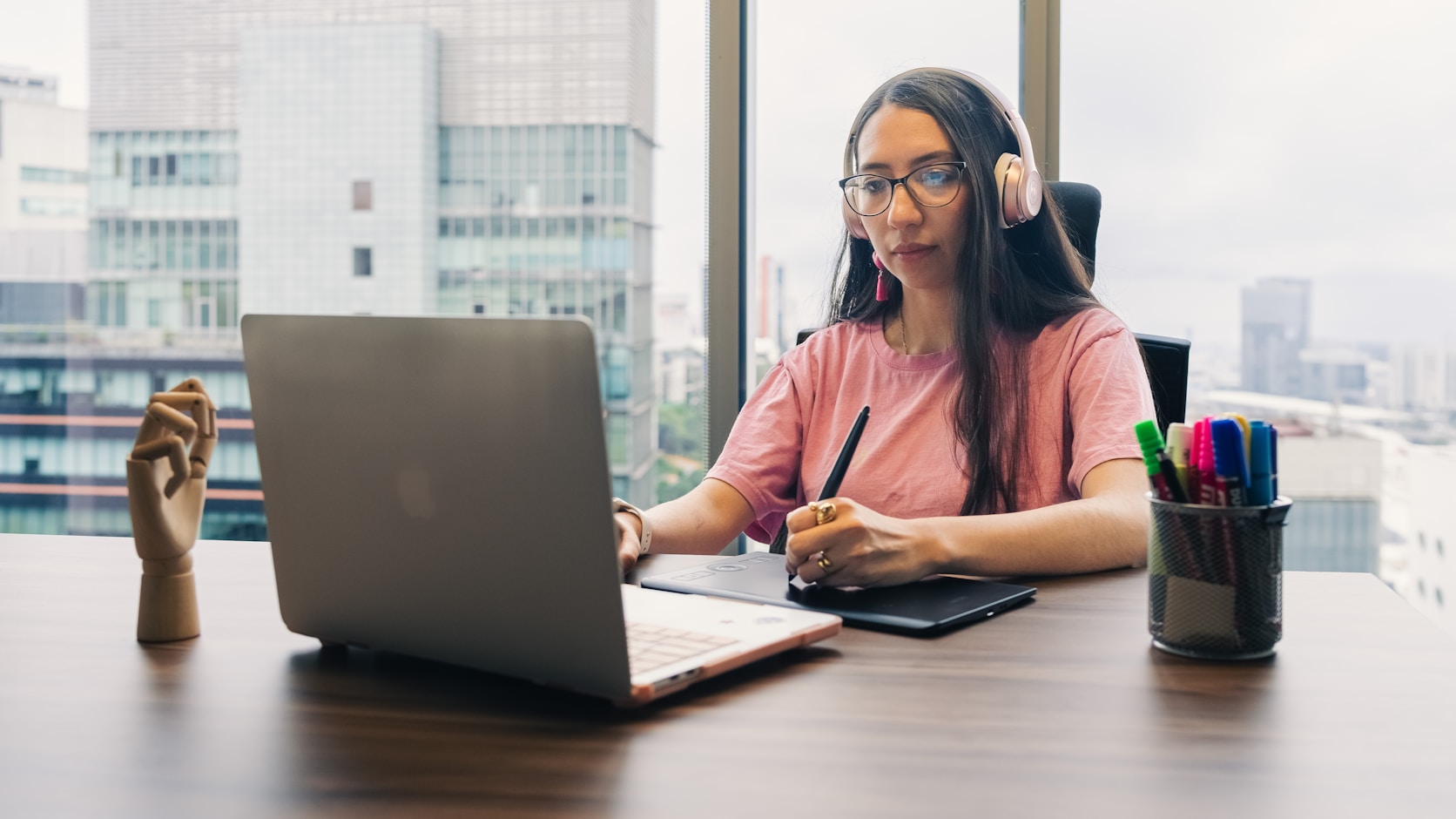 A designer working at a laptop with a stylus