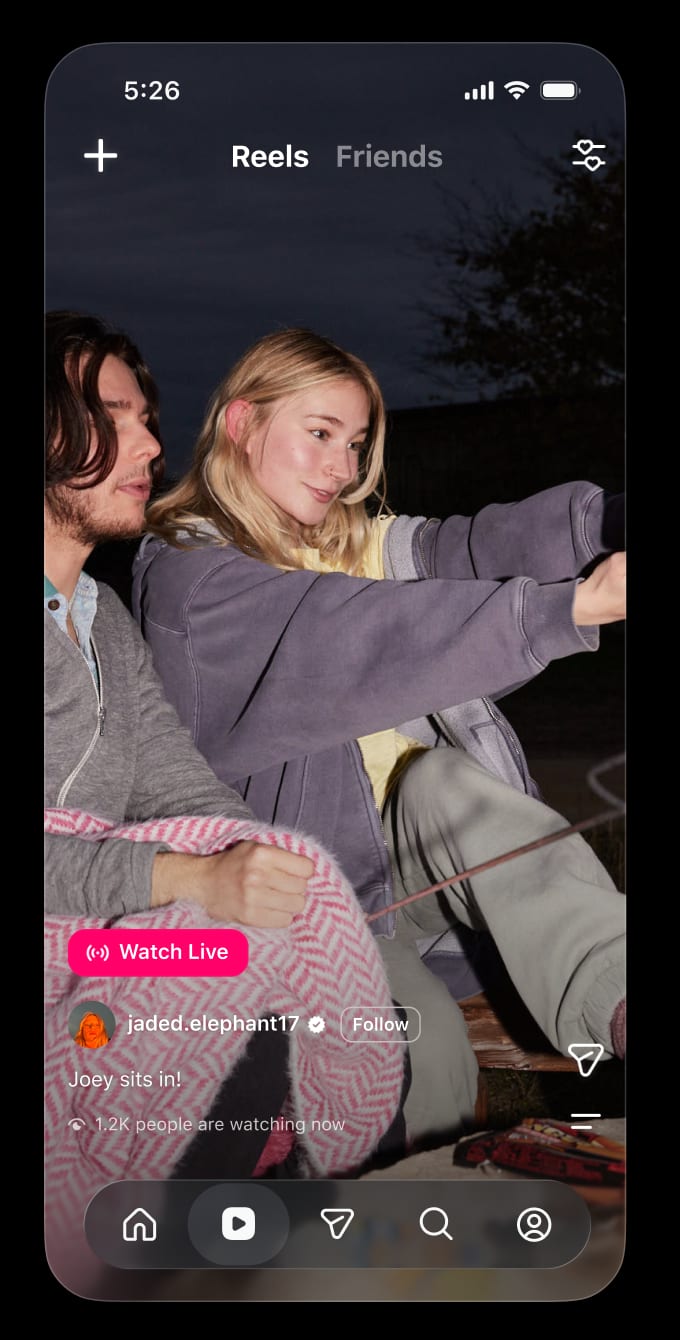 A Reel of two friends at a campfire with a pink Watch Live button and 1.2K people are watching now