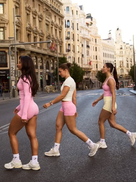 An Instagram story ad by Gymshark in Meta's Ad Library: three women in pink and yellow Gymshark sets cross a city street