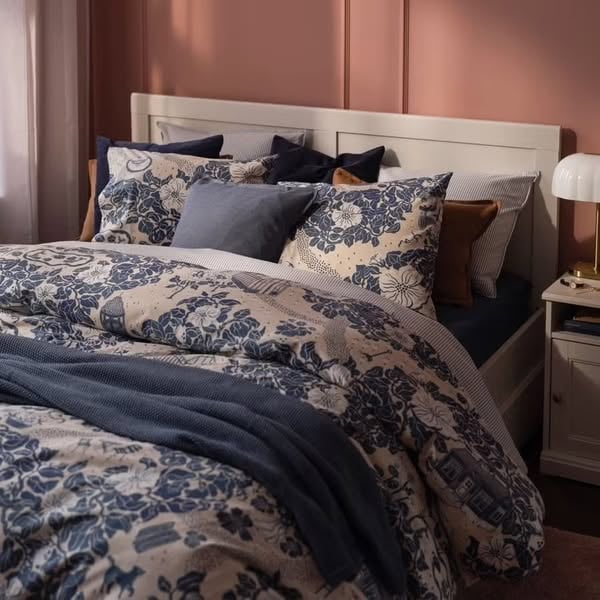 An ad by ELLE DECOR with IKEA in Meta's Ad Library: Make your bedroom feel like a boutique hotel with these new IKEA textiles, over a bed with blue floral bedding