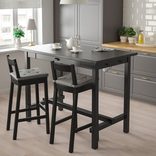 An ad by IKEA in Meta's Ad Library: Renueva tu cocina con IKEA por un precio sabrosísimo, over the NORDVIKEN black bar table with two bar stools in a gray kitchen