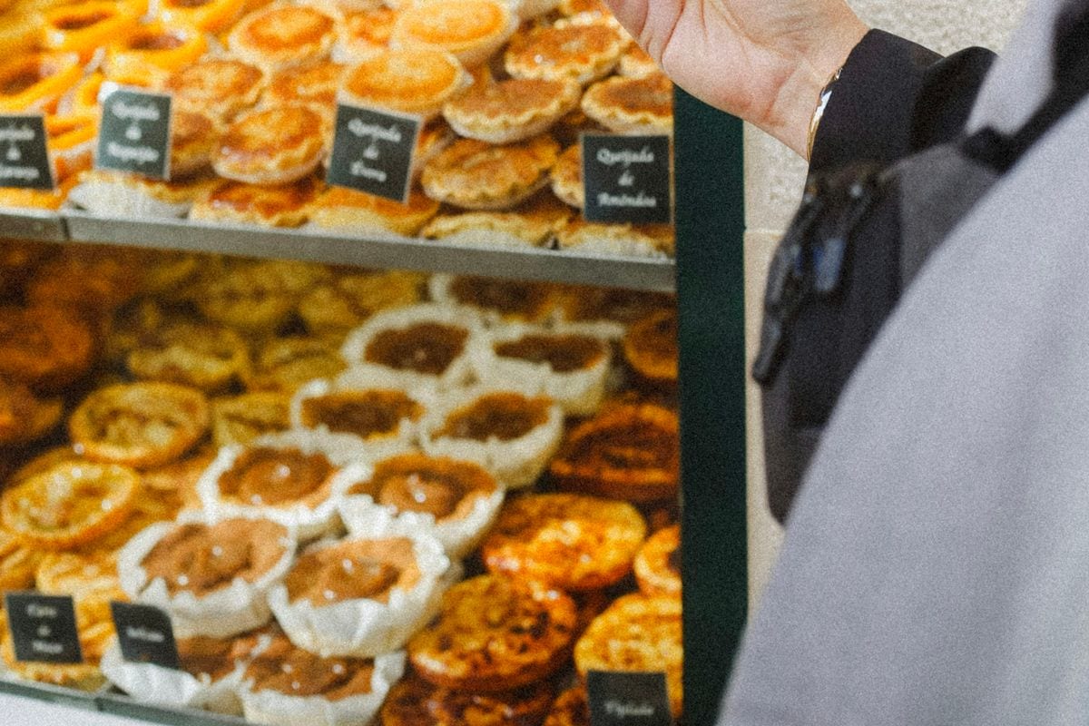 A customer filming a bakery display case on her phone: a product that looks good on camera sells itself in 15 seconds
