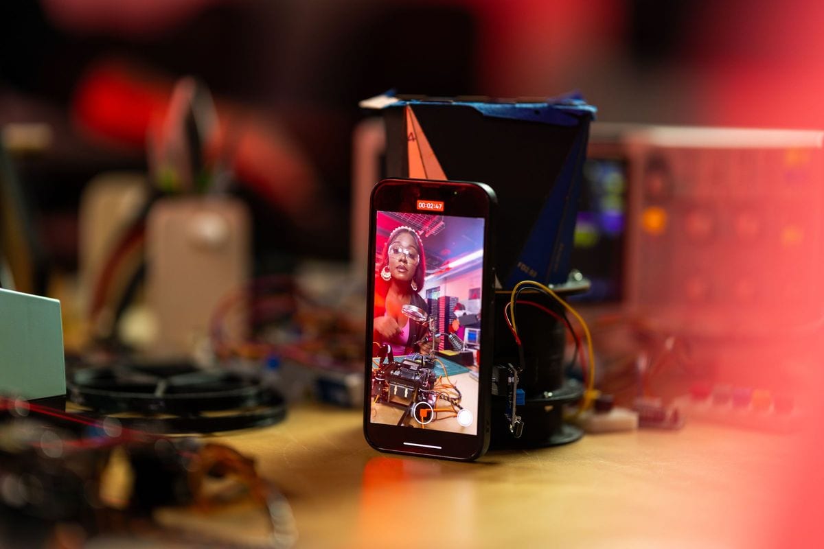 A phone recording on a workbench among cables and tools: a small business can film the whole week on one phone and one steady surface