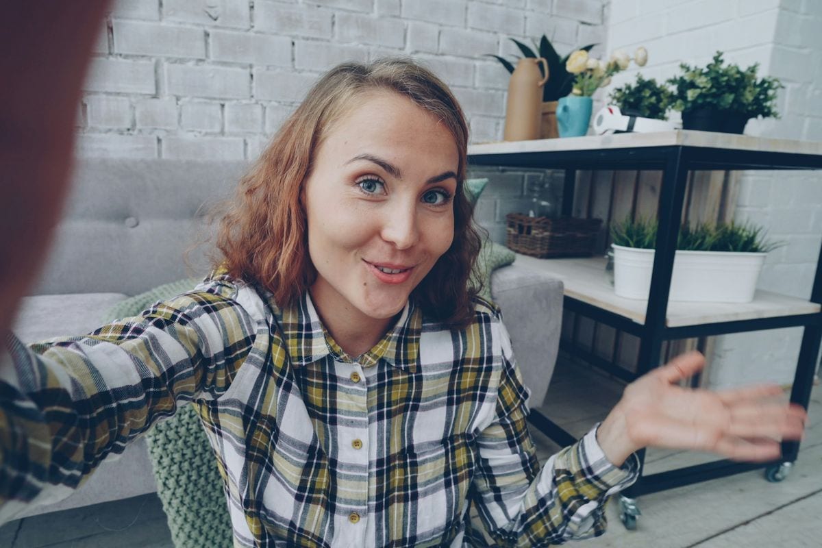 A woman talking to her phone camera from her living room: a talking-head TikTok needs one point and one take