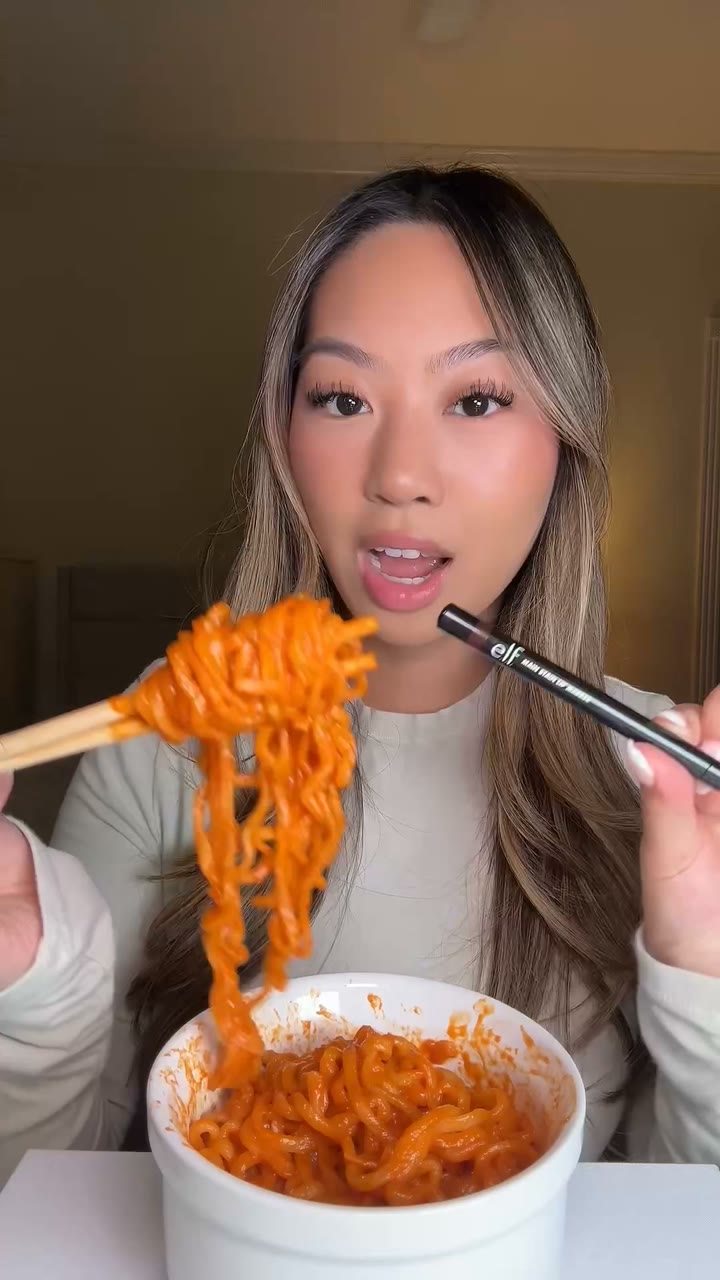 An e.l.f. Cosmetics creator ad on Meta: a woman eating red ramen with chopsticks while holding a lip marker