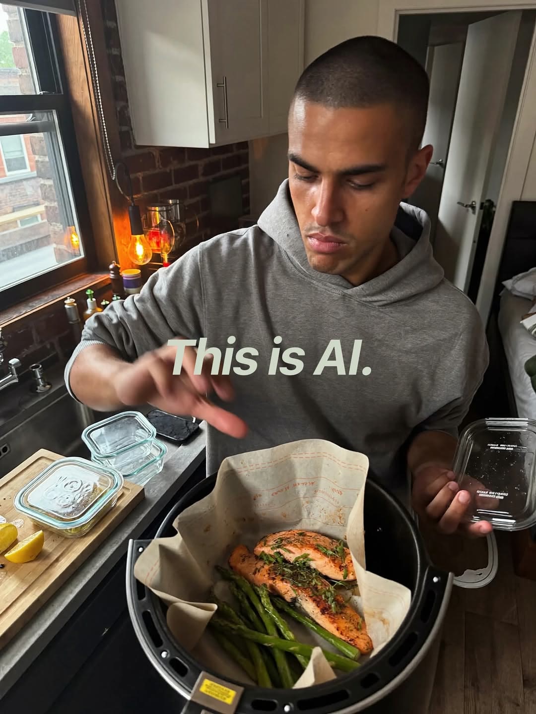 An AI-generated phone-style shot of a man lifting salmon and green beans out of an air fryer in his kitchen, stamped This is AI.