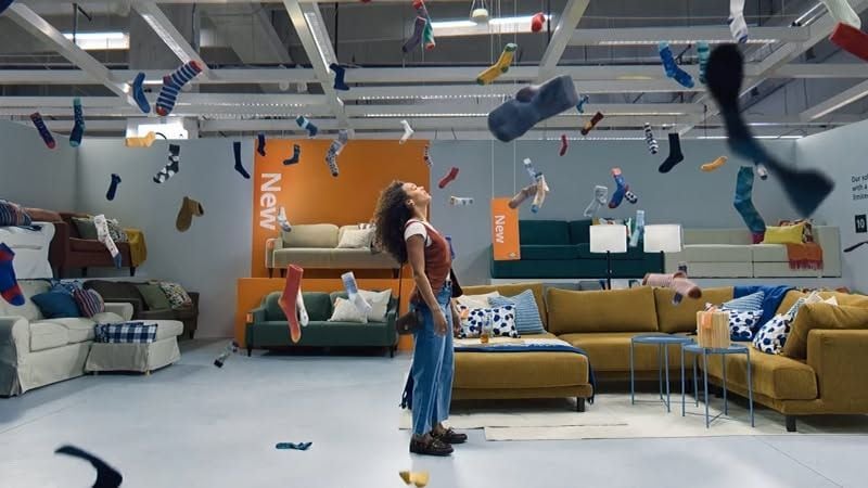 IKEA US's profile cover: a showroom with a sofa and hanging shelves
