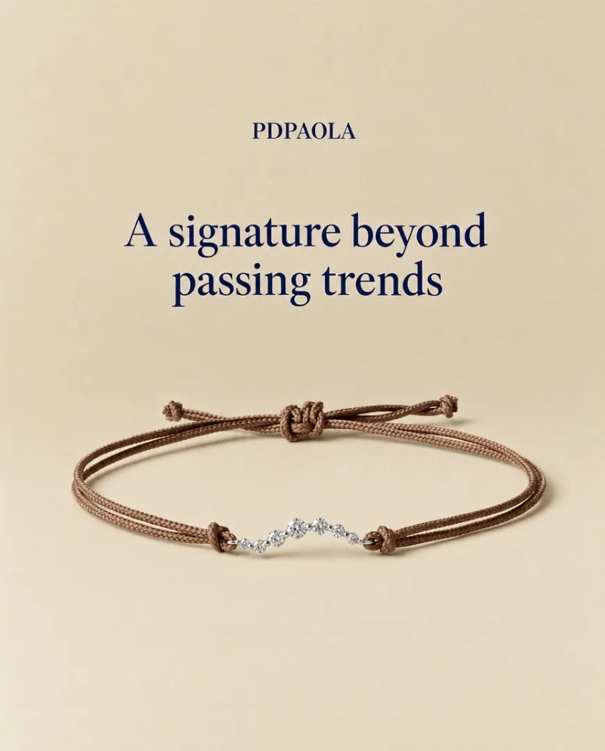 A Selzee ad for a PDPAOLA cord bracelet with a curved diamond bar on a beige background